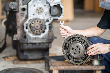 Mechanic man holding front Gear of diesel commonrail engine in heavy machinery workshop