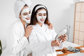 Wall Mural - Beautiful young women with applied facial masks in bathroom