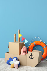 Poster - Toy cardboard ship in children's room near blue wall