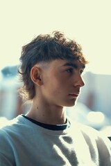 Vertical portrait of a young Caucasian boy with a fresh mullet haircut