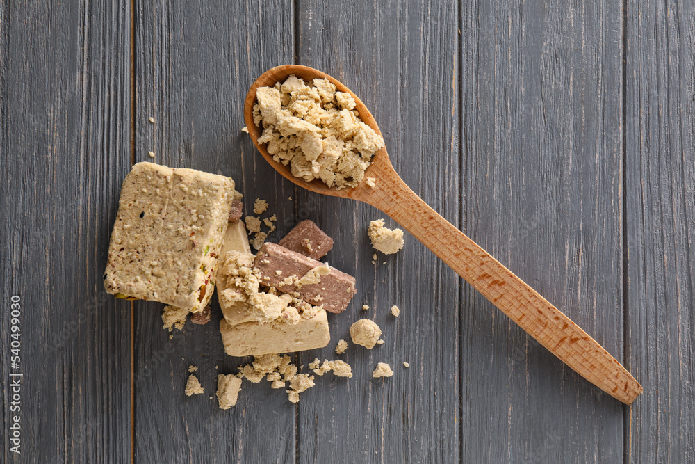 Spoon with crushed sesame halva on dark wooden background