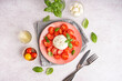Composition with tasty mozzarella cheese, tomatoes, basil and oil on light background