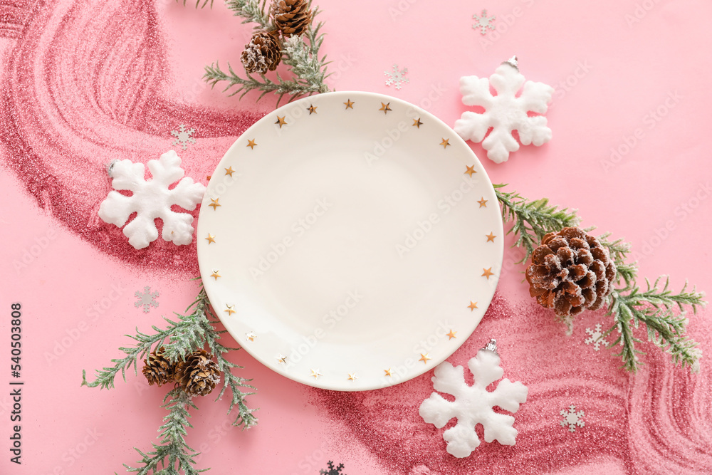Composition with plate and Christmas decorations on pink background