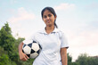 © paltu - young girl standing on the field holding the soccer ball