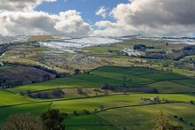 Birds-eye View Looking Into A Valley Of Green Fields With A Steep Mountainous Slope And Snow At The Top In Early Spring, Nidderdale, England, UK.
