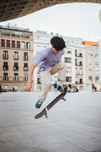 Focus Boy Skateboarding. He Is Doing An Ollie Trick In The Middle Of The City