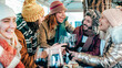 © charmedlightph - Friends group with hats and scarves toasting with glasses of red wine at bar restaurant - Winter holidays concept with people enjoying time and having fun drinking and eating together