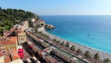 Beautiful Panorama Of English Promenade In Nice, France. Palm Trees, Old Houses In Old Town Azure Sea And Green Hills. Summer In French Riviera. View From Sky, Drone Video 