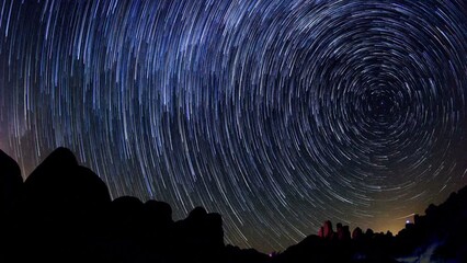 Wall Mural - Lockdown Time Lapse Shot Of Sparkling Star Trails By Rocks At Night - Joshua Tree, California