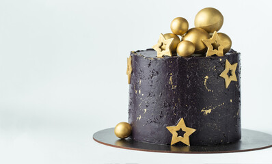 Canvas Print - Luxury cake with dark blue cream cheese frosting decorated with golden chocolate stars and spheres. Birthday space themed cake on the white background