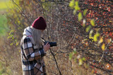 Fototapeta  - Kobieta fotograf, blond włosy wykonująca zdjęcia przyrody jesienią.