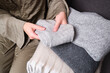 © Iuliia Pilipeichenko - A young woman holds warm knitted sweaters and puts them in a basket. Cozy angoras or cashmere things. Things after washing