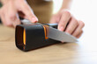 Woman sharpening knife with special knife sharpener