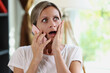 Surprised and shocked woman speaking on phone