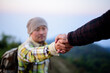 © Johnstocker - Close-up of Two male hikers helping each other climb up a mountain