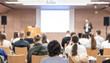 © kasto - Speaker giving a talk in conference hall at business event. Rear view of unrecognizable people in audience at the conference hall. Business and entrepreneurship concept.