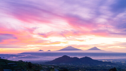 Wall Mural - Beautiful dramatic reddish orange sunrise sky with mountain range - Merapi Volcano, Merbabu, Telomoyo and Andong Mountain