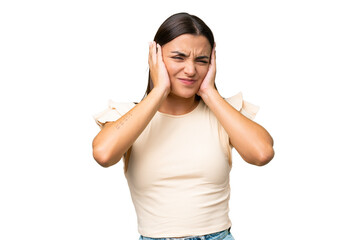 Poster - Young caucasian woman isolated on green chroma background frustrated and covering ears