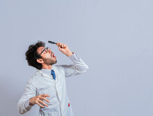 Surprised Man In Lab Coat With Magnifying Glass Looking At An Advertisement Above. Scientist Man Looking Up With A Magnifying Glass. Amazed Man Observing An Advertisement With A Magnifying Glass