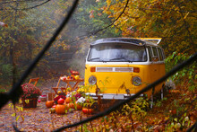 Fall Composition With Old Van, Pumpkins, Flowers And Picnic Chairs And Table On The Autumn Forest Background