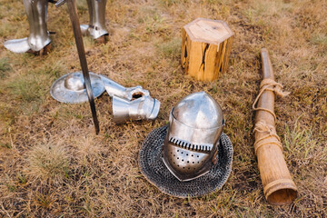 Knight's helmet, sword and battle horn on the ground