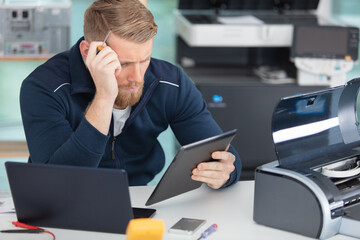 man repairing photocopier using screwdriver