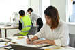 © Prathankarnpap - Focused architects woman checking construction blueprints on wooden table at her workplace