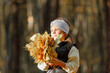 © Ruslan Ivantsov - Beautiful little girl wearing playing with dry leaves throwing them into the air