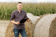 © Ruslan Ivantsov - young agronomist holds a paper chart in his hands and analyzes the corn crop