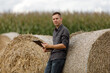 © Ruslan Ivantsov - young agronomist holds a paper chart in his hands and analyzes the corn crop