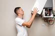 © Ruslan Ivantsov - a man in uniform repairing a gas boiler