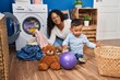© Krakenimages.com - Mother and son smiling confident washing clothes at laundry room