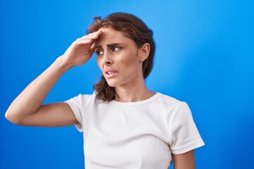 Poster - Young beautiful hispanic woman suffering for headache standing over isolated blue background