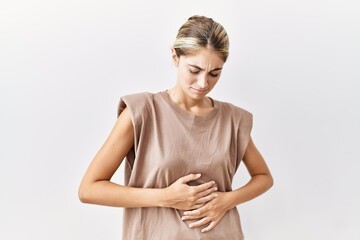 Poster - Young blonde woman standing over isolated background with hand on stomach because indigestion, painful illness feeling unwell. ache concept.