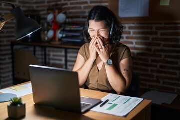 Sticker - Young hispanic woman working at the office at night laughing and embarrassed giggle covering mouth with hands, gossip and scandal concept