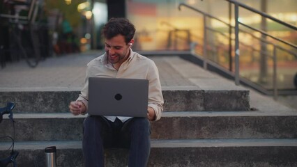 Wall Mural - Young man relaxing while talking over laptop.