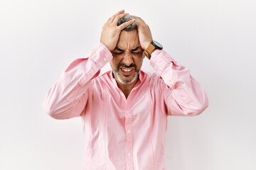 Poster - Middle age hispanic man standing over isolated background suffering from headache desperate and stressed because pain and migraine. hands on head.