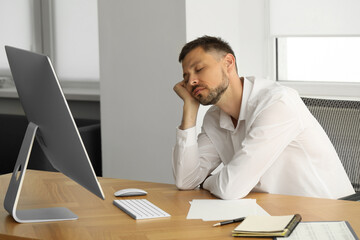 Wall Mural - Sleepy man snoozing at workplace in office