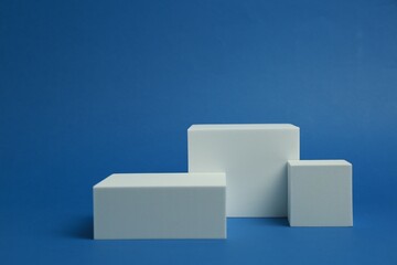 Poster - Product photography props. Podiums of different geometric shapes on blue background