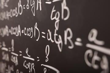 Sticker - Different mathematical formulas written with chalk on blackboard, closeup