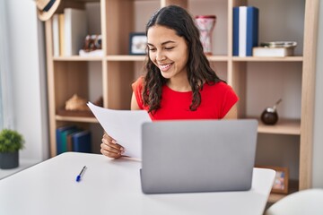 Sticker - Young african american woman using laptop reading document sitting on table at home