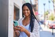 © Krakenimages.com - African american woman smiling confident using smartphone at street