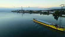 Panoramic Drone View Of A Barge Floating In Dense Fog On The Rhone River In The Morning. In The Town Of Le Pouzin In France. Wind Power Plant In The Background