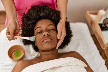 Sticker - Young african american woman having facial treatment at beauty center