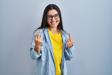 Poster - Young hispanic woman standing over blue background showing middle finger doing fuck you bad expression, provocation and rude attitude. screaming excited