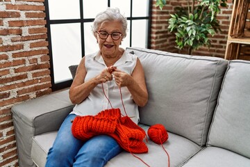 Wall Mural - Senior grey-haired woman smiling confident sewing using lane and needle at home