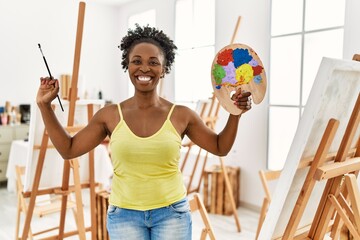 Wall Mural - Young african american artist woman smiling happy drawing at art studio.