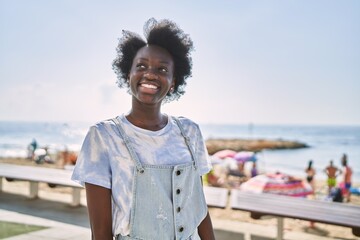 Wall Mural - Young african woman smiling confident by the sea