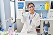 © Krakenimages.com - Young brunette woman working at scientist laboratory smiling happy pointing with hand and finger