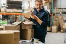 Mature Man Packing Orders In A Warehouse